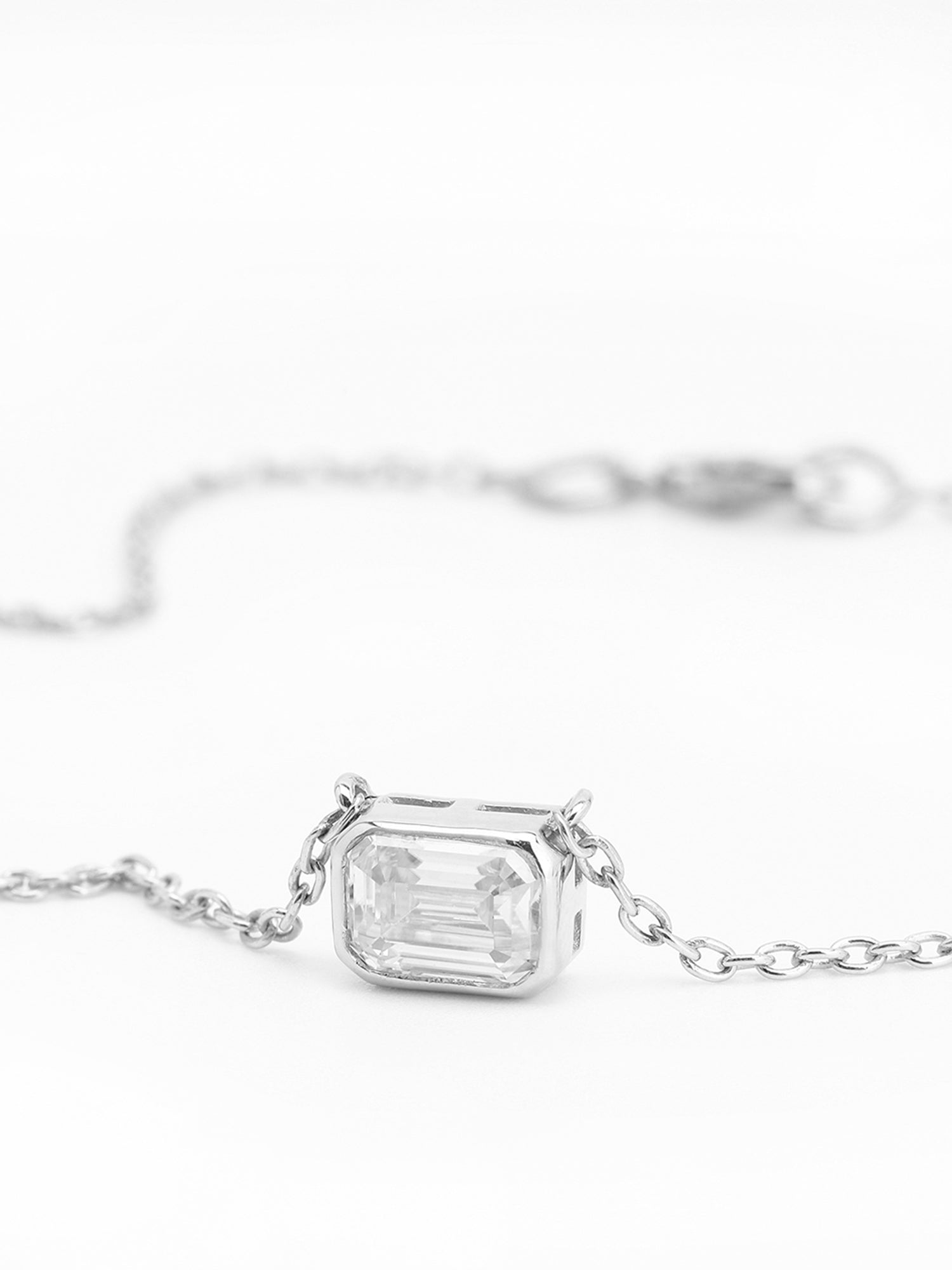 Timeless solitaire pendant with a emerald-cut gemstone in a prong setting.