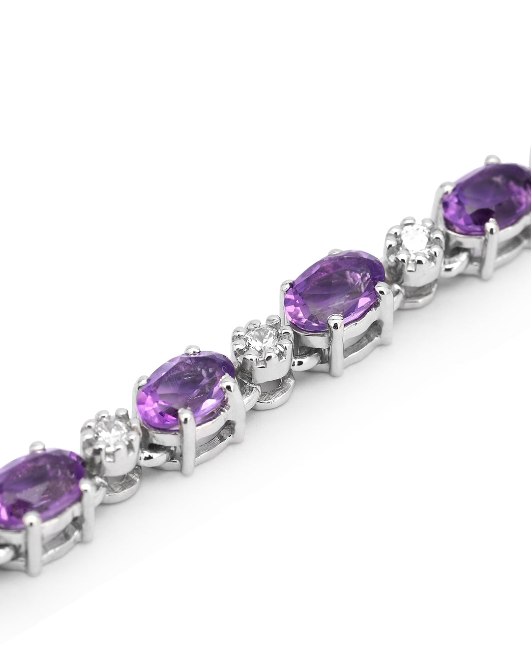 Elegant tennis bracelet with oval-cut gemstones in fine metal.