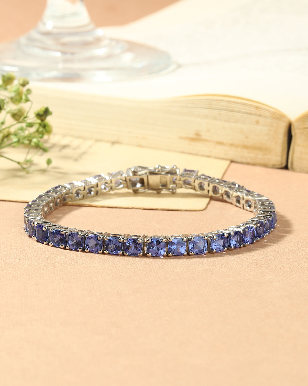 Elegant tennis bracelet with cushion-cut gemstones in fine metal.