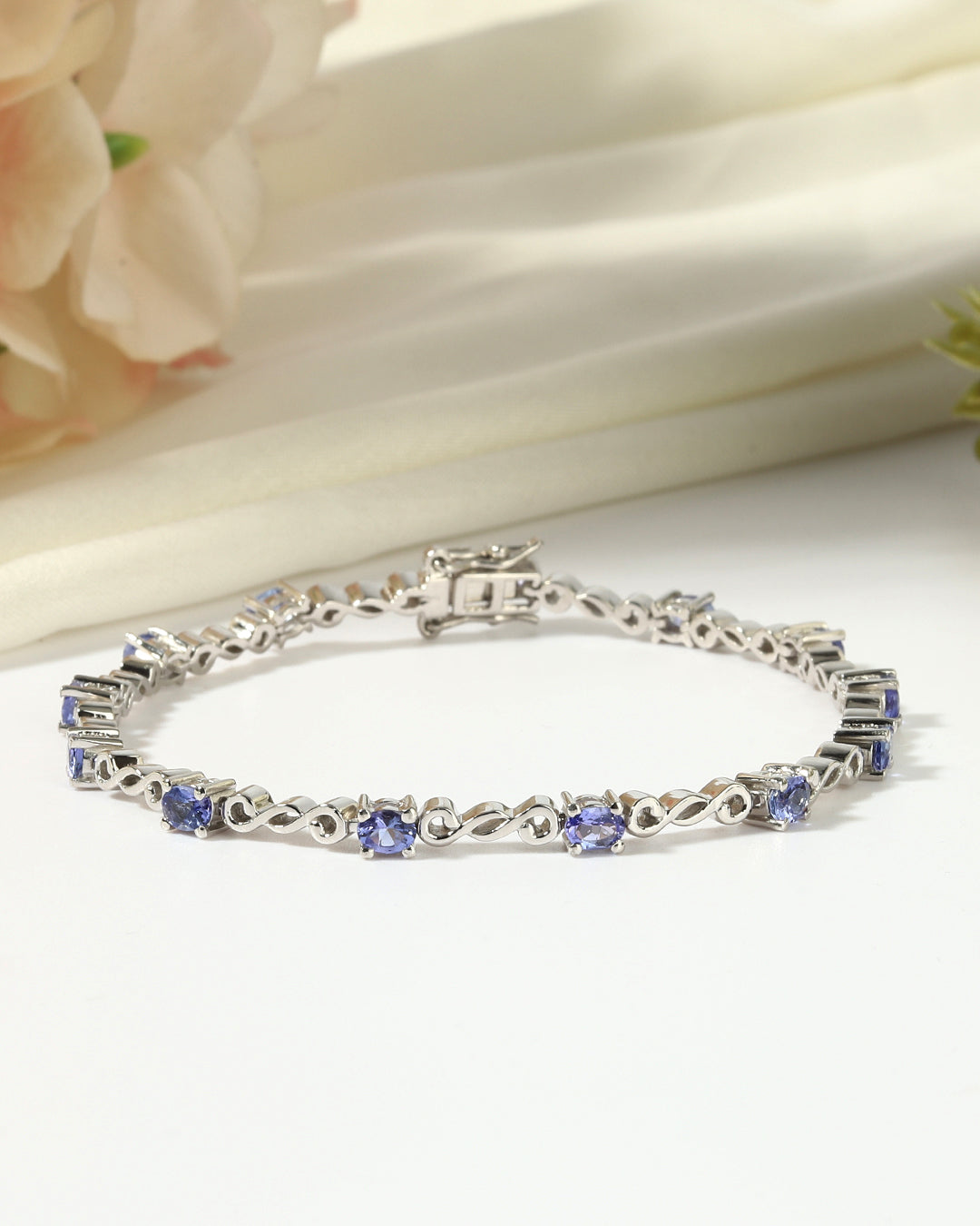 Elegant tennis bracelet with round-cut gemstones in fine metal.