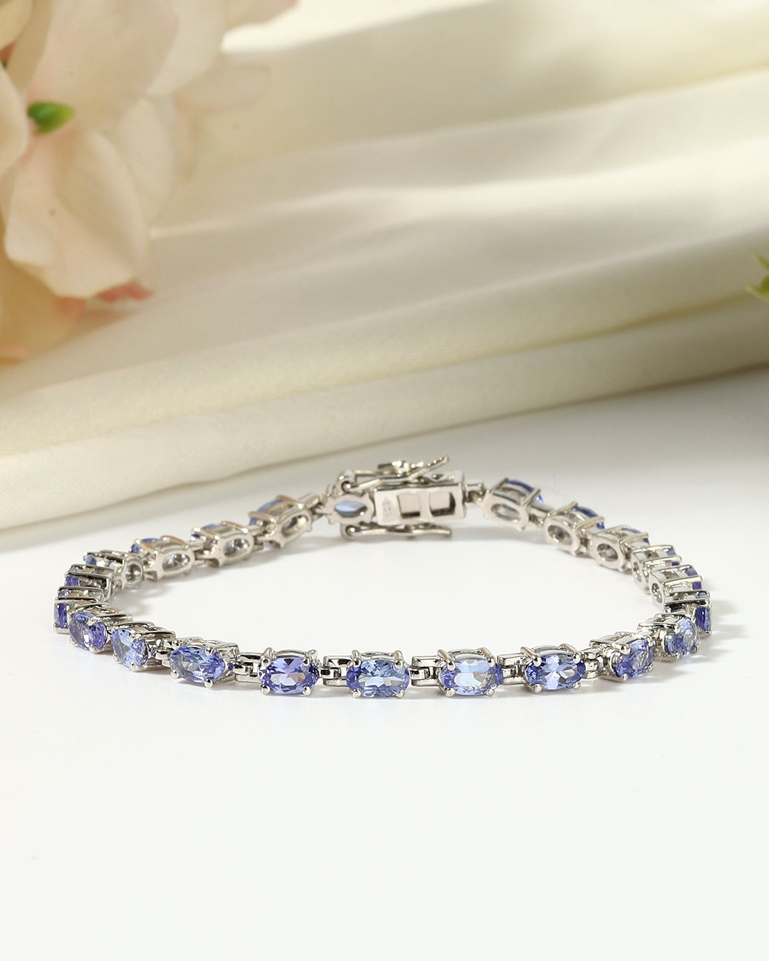 Elegant tennis bracelet with round-cut gemstones in fine metal.