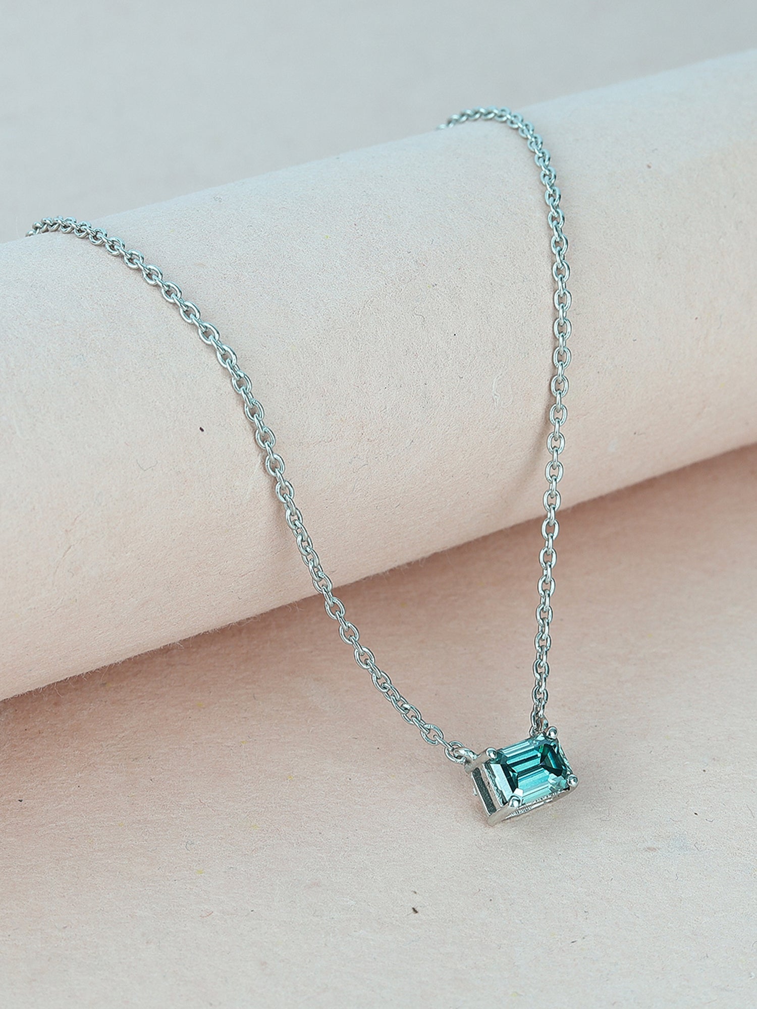 Timeless solitaire pendant with a emerald-cut gemstone in a prong setting.