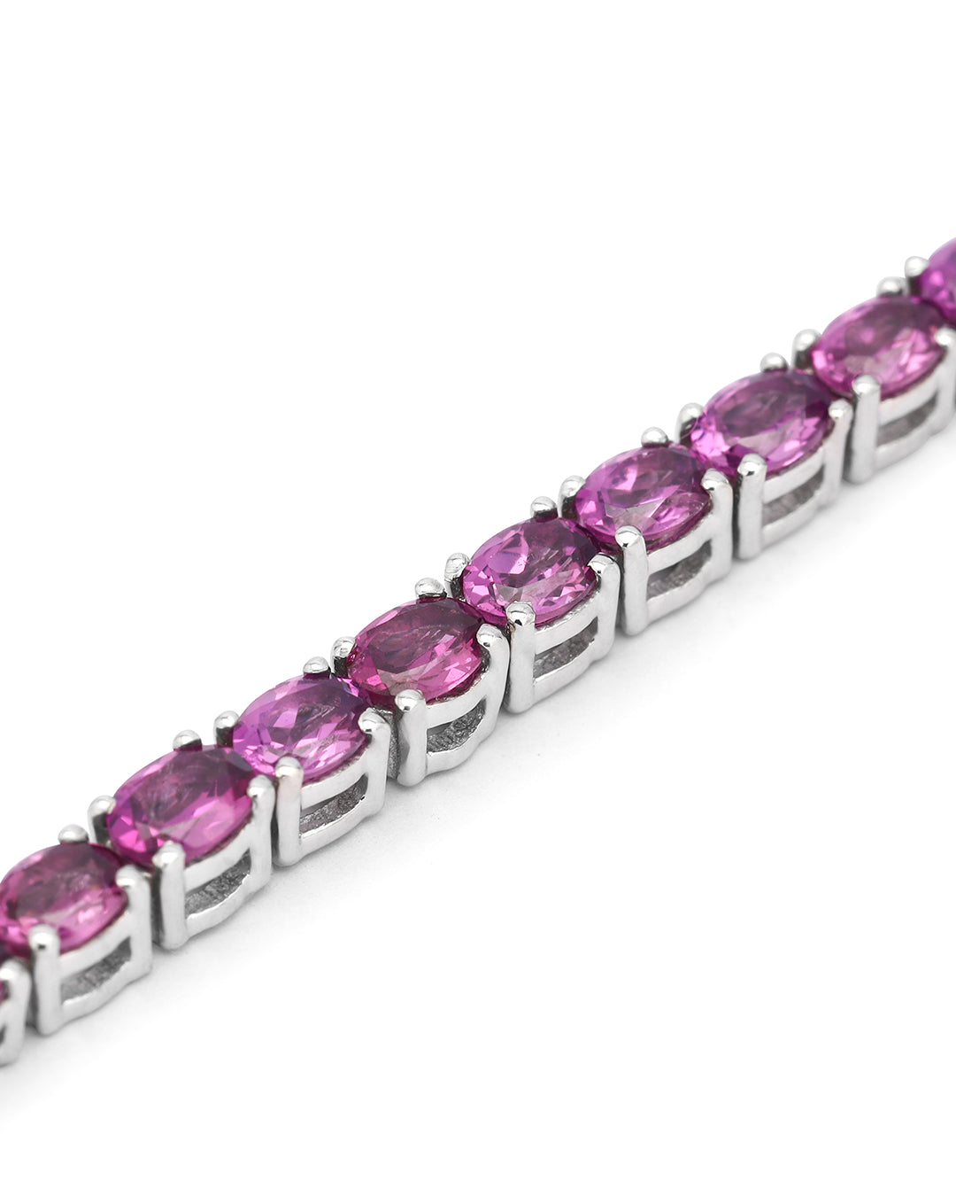 Elegant tennis bracelet with oval-cut gemstones in fine metal.