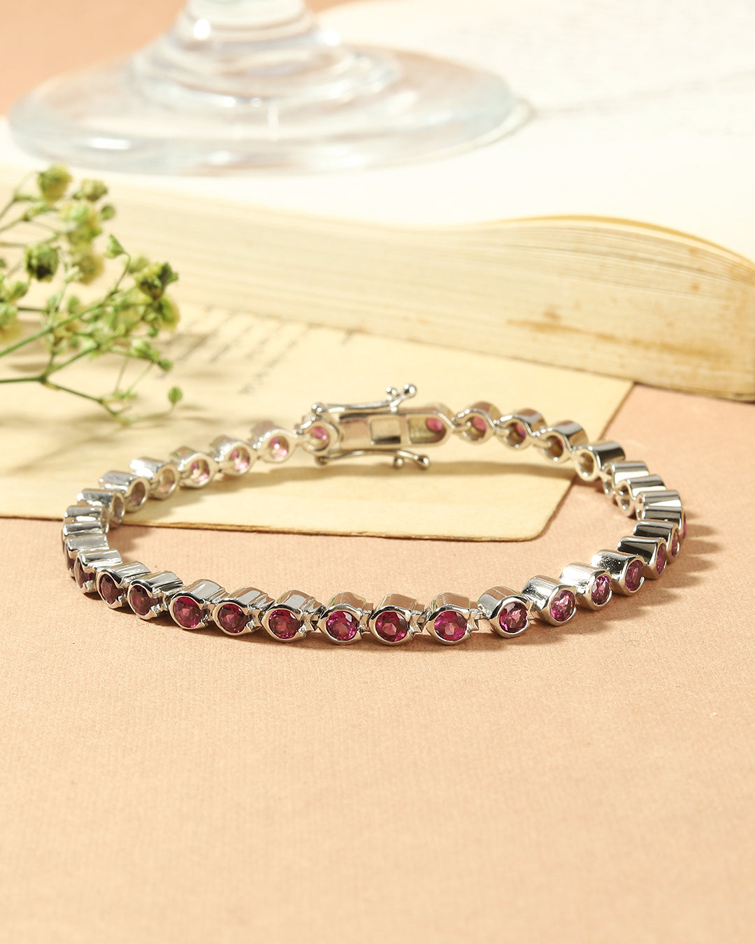 Elegant tennis bracelet with round-cut gemstones in fine metal.