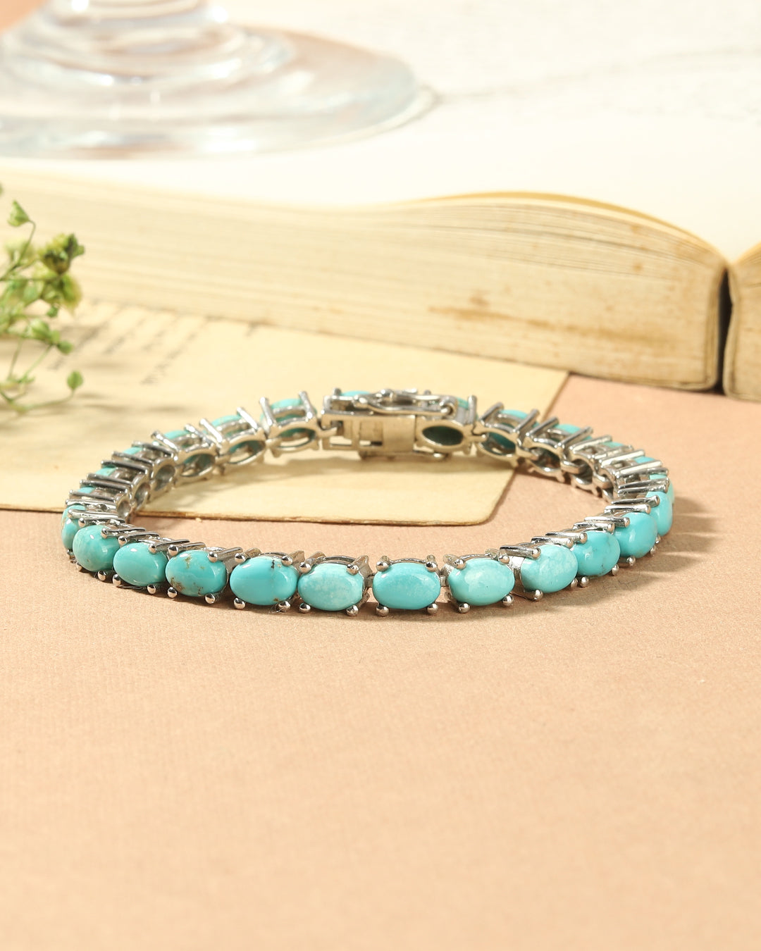 Elegant tennis bracelet with oval-cut gemstones in fine metal.