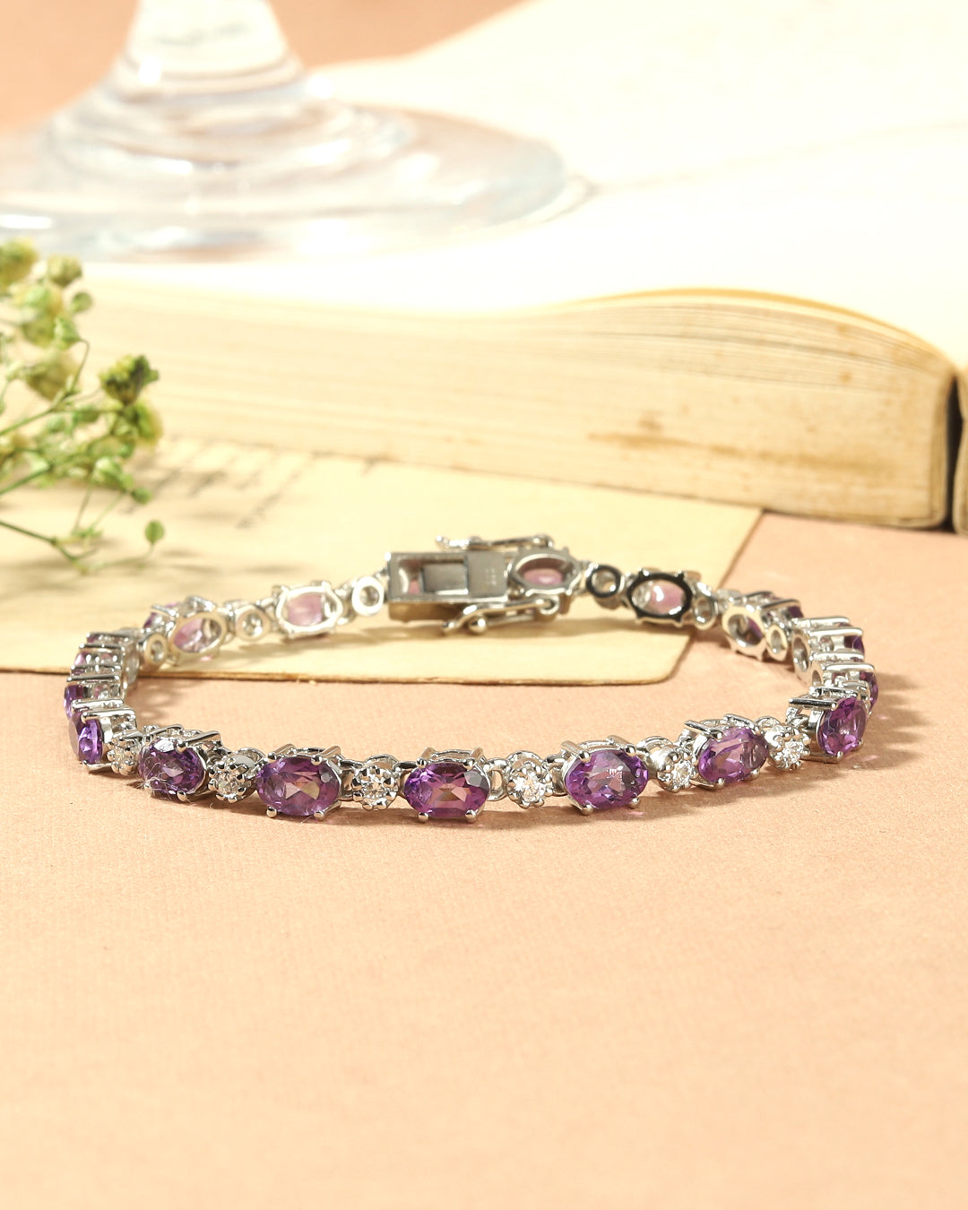 Elegant tennis bracelet with oval-cut gemstones in fine metal.