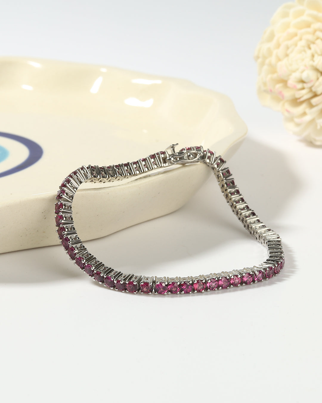 Elegant tennis bracelet with round-cut gemstones in fine metal.