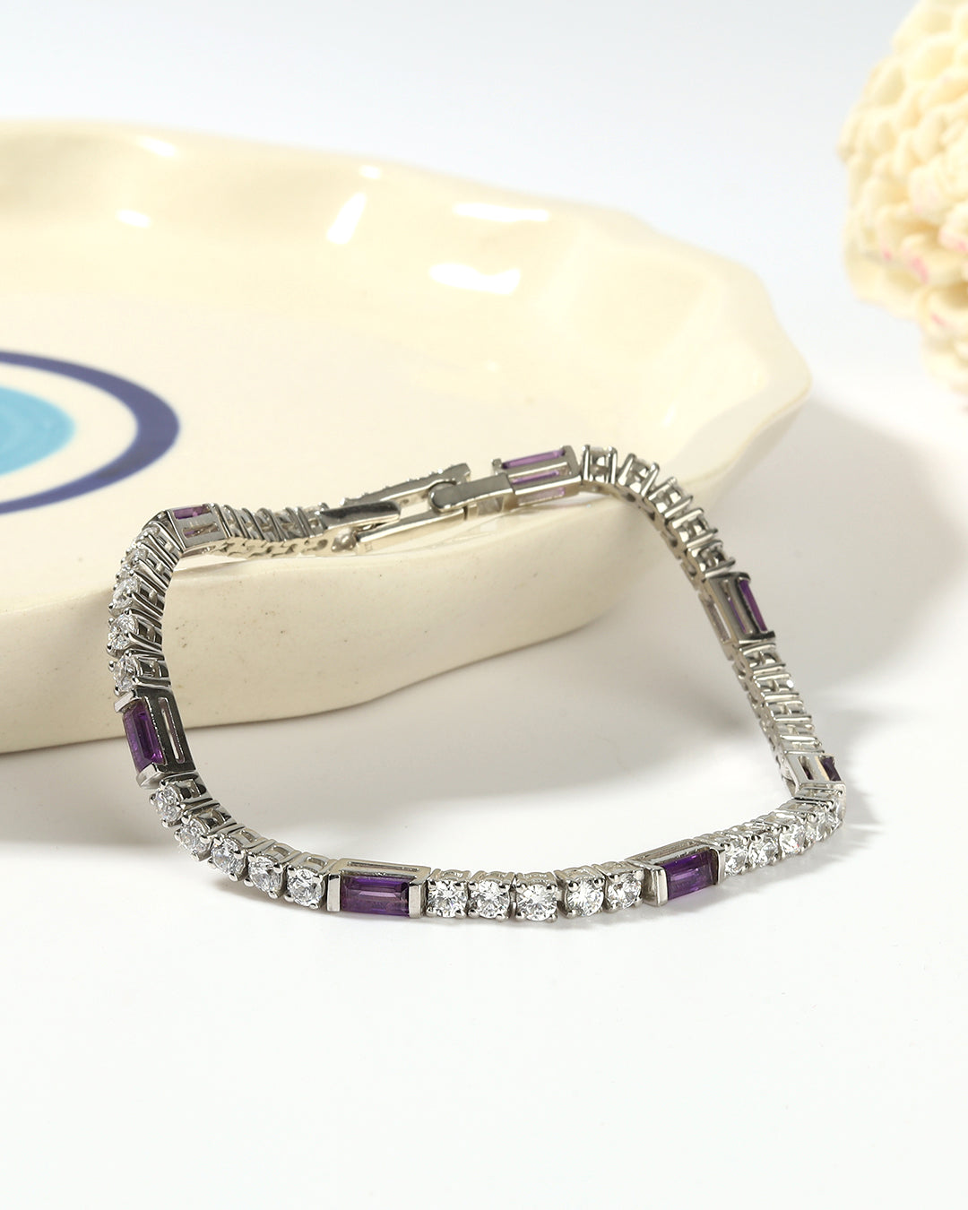 Elegant tennis bracelet with round-cut gemstones in fine metal.