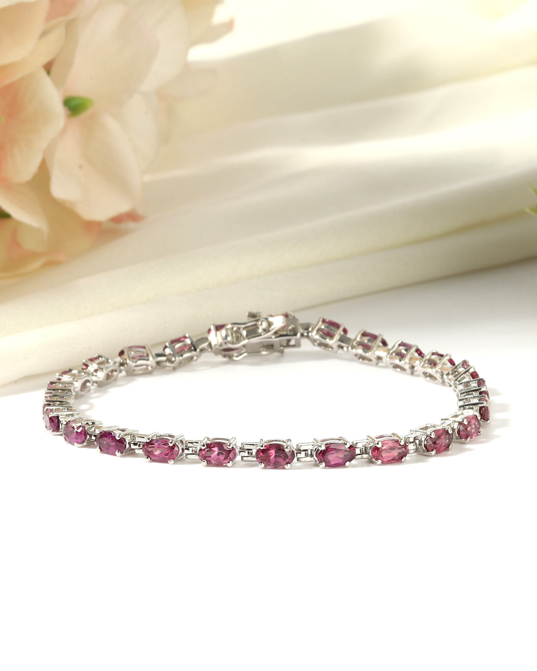  Elegant tennis bracelet with round-cut gemstones in fine metal.