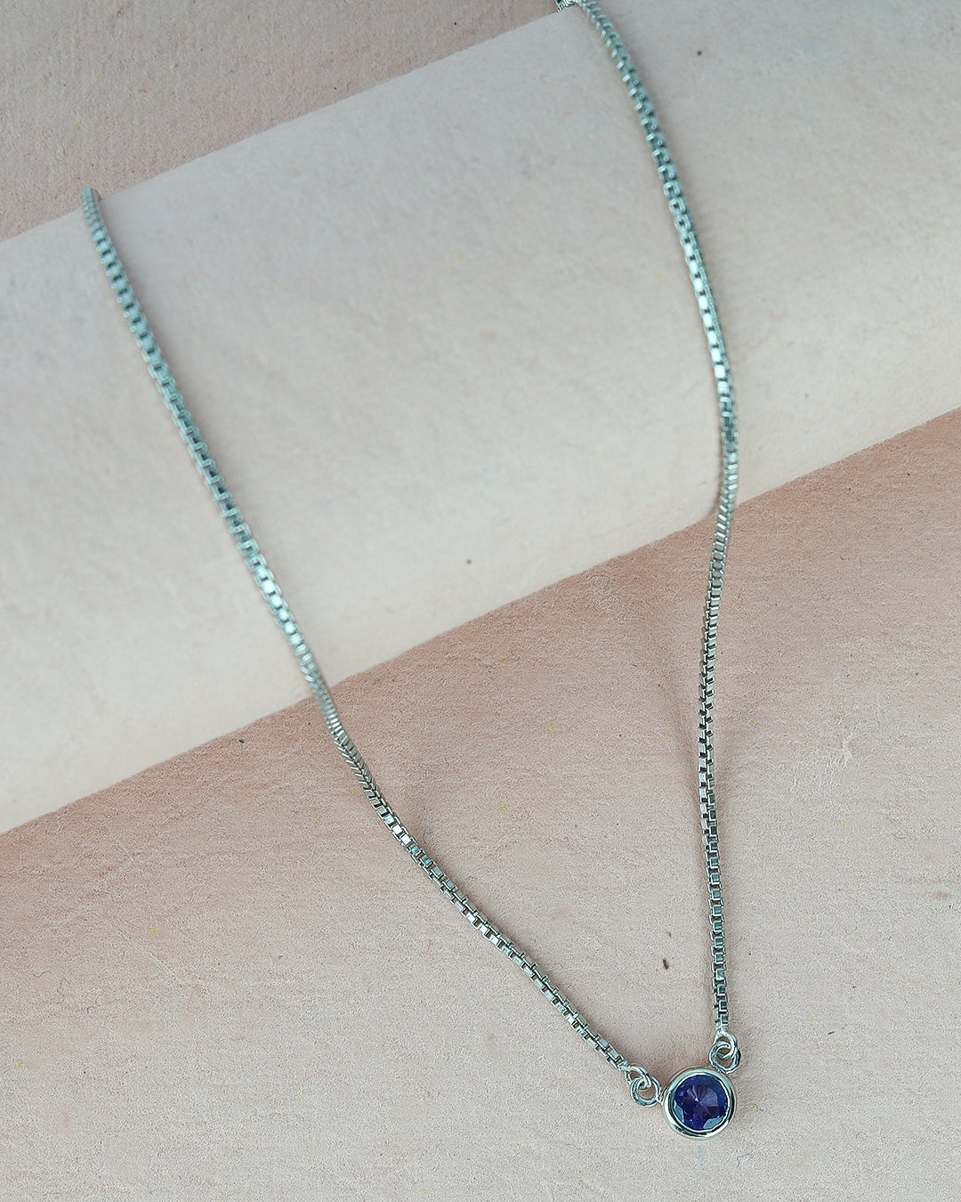 Timeless solitaire pendant with a round-cut gemstone in a prong setting.